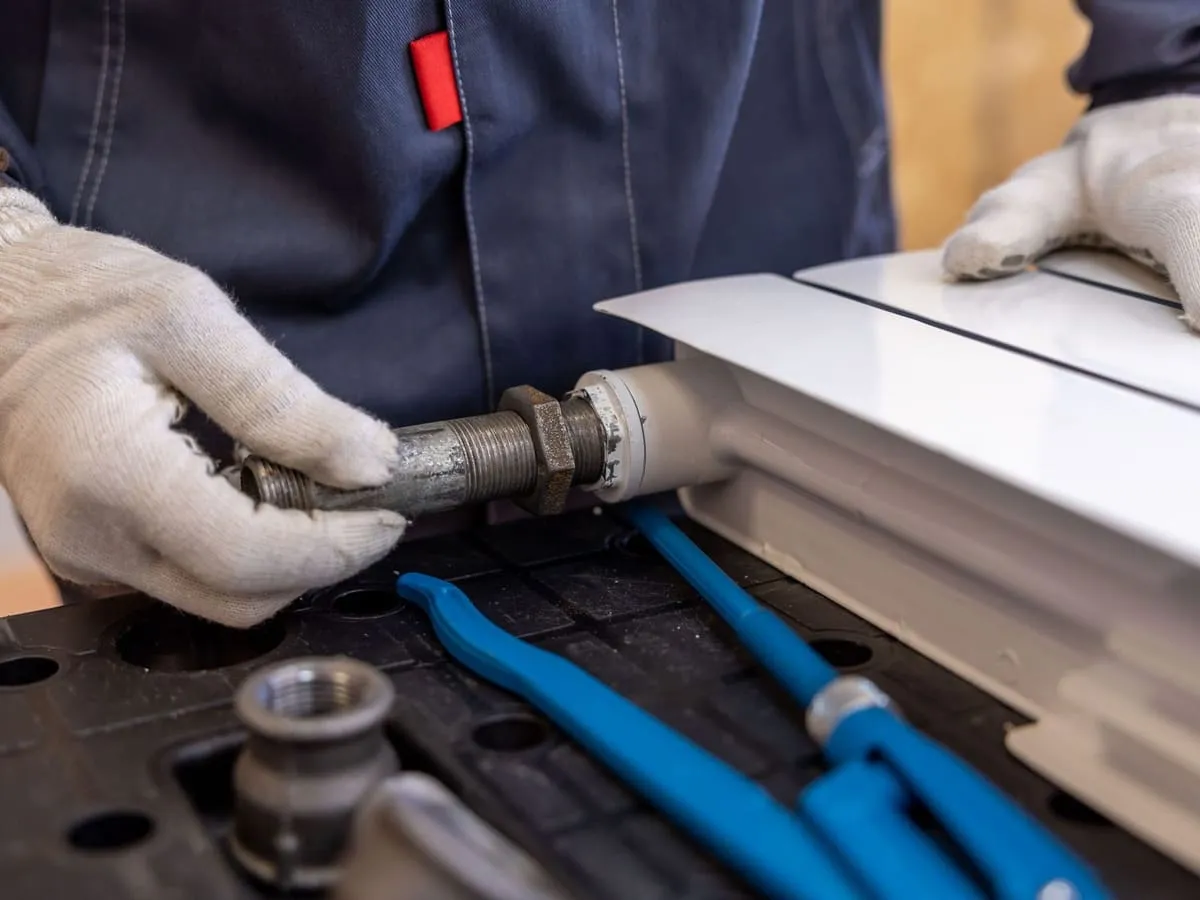 A tradesperson connecting radiator pipework on site