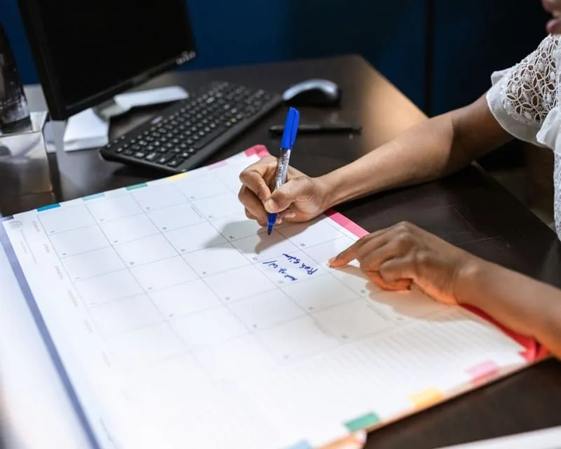 Hands scheduling a job on a calendar